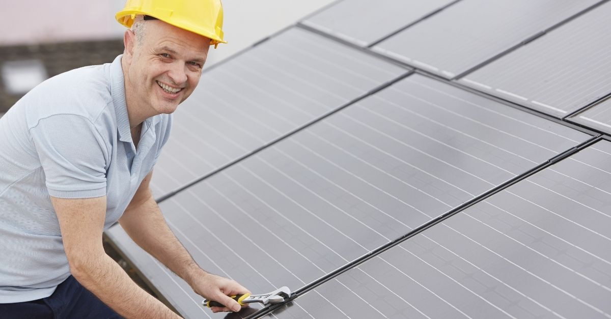 Person cleaning multiple solar panels